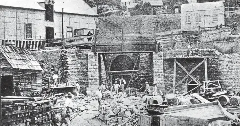 ??  ?? The tunnel under constructi­on, with provincial engineer Edward Dobson, in his distinctiv­e white top hat, to the right of the tunnel entrance.