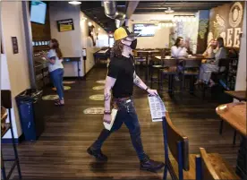  ??  ?? Bartender Jack Seale at Beer Wall on Penn in West Reading on Thursday. General manager Josh Stenchever suggested the financial instabilit­y during the COVID pandemic may be driving workers from the industry.