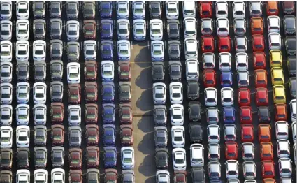  ??  ?? In this January 2017 photo, cars are parked waiting to be exported at Yokohama port near Tokyo. Japan’s government has warned in a report that a higher U.S. tariff on auto imports could backfire, jeopardizi­ng hundreds of thousands of American jobs...