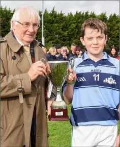  ??  ?? Brendan Furlong of People Newspapers (sponsors) with victorious St. James’ captain Colum Fitzgerald.