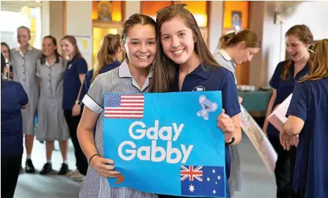  ?? PHOTO: KEVIN FARMER ?? GDAY: St Ursula's College student Eve Beattie-Zarb (left) holds a welcome poster with her Ursuline Academy of Dallas exchange partner Gabby Sharp.