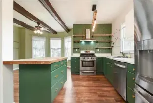  ?? ?? The kitchen has green cabinetry and Arts and Crafts-style wallpaper.