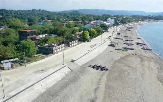  ?? PHOTOGRAPH COURTESY OF DPWH ?? THE Department of Public Works and Highways has completed the seawall project in Barangay Taboc in the coastal town of San Juan, La Union. The P29-million flood mitigation structure, a 155-meter wall, protect residents, tourists, and motorists from waves during torrential downpours and severe weather conditions.