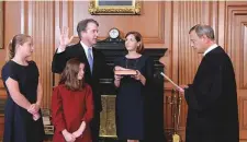  ?? Reuters ?? Judge Brett Kavanaugh is sworn in as Associate Justice of US Supreme Court by Chief Justice John Roberts as Kavanaugh’s wife Ashley holds the family bible in the company of daughters Liza and Margaret on Saturday.
