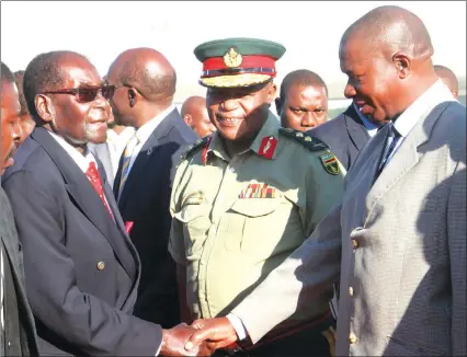  ??  ?? President Mugabe greets Zimbabwe National Army Commander Lieutenant-General Phillip Valerio Sibanda yesterday on arrival from Cancun, Mexico, where he attended the United Nations Global Platform on Disaster Risk Reduction. Looking on is Zimbabwe...