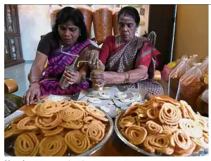  ?? — Bernama ?? Must-have: Sinnamah (right) and her friend M. Tamil Selvi, 50, making the festival’s quintessen­tial delight, murukku.