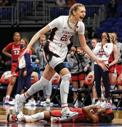  ?? Elsa / Getty Images ?? Stanford’s Cameron Brink celebrates the Cardinal’s national title as Arizona’s Aari McDonald lies on the Alamodome court.