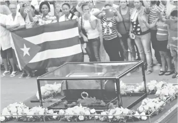  ??  ?? The caravan carrying the ashes of Fidel Castro pass along a street in Bayamo, Cuba, on its way to the eastern city of Santiago de Cuba. — Reuters photo