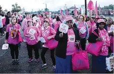  ?? Staff file photo by Hunt Mercier ?? Breast cancer survivors march with fans stating how many years they have been cancer free Oct. 20, 2018, on Front Street in downtown Texarkana before the Race for the Cure 5K event.