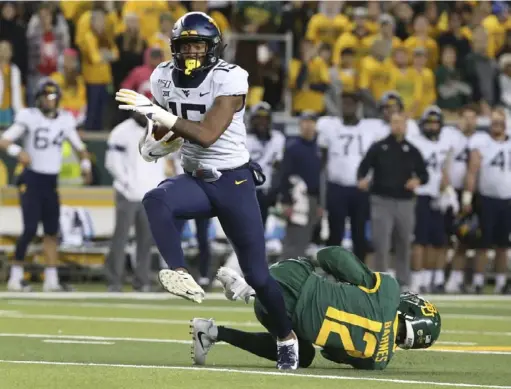 ?? Associated Press ?? West Virginia’s George Campbell runs past Baylor’s Kalon Barnes on his way to a touchdown in the Mountainee­rs’ 17-14 loss Oct. 31 in Waco, Texas. The 83-yard score accounted for a large chunk of West Virginia’s 219 total yards as the offense continued to struggle.