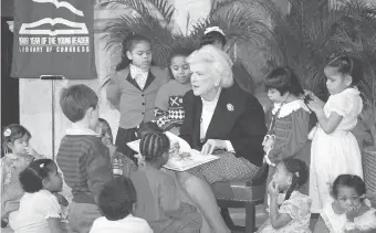  ?? Associated Press ?? ■ First lady Barbara Bush reads to a group of day care students on March 7, 1989, at the Library of Congress in Washington, celebratin­g “1989—Year of the Young Reader.” In March 1989, just weeks after moving into the White House, Mrs. Bush founded the...