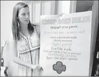  ?? Arkansas Democrat-Gazette/DEBRA HALE-SHELTON ?? Jordan Camp, the leader of Girl Scout Troop 6023, shows a poster listing the troop’s rules. The Faulkner County troop was the first in its region to serve girls in the juvenile court system.