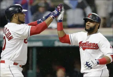  ?? TONY DEJAK — THE ASSOCIATED PRESS ?? Edwin Encarnacio­n, left, and Carlos Santana celebrate after both scored in the sixth inning against the Rangers on June 26 at Progressiv­e