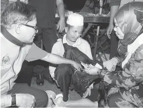  ?? — Gambar Bernama ?? TURUN PADANG: Halimaton (kanan) memeriksa beg seorang pengemis warga Kemboja pada Program Kesedaran Pencegahan Pengemisan dan Operasi Menyelamat Orang Papa di Pasar Malam Kepala Batas semalam.