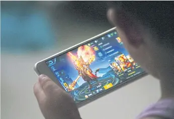  ??  ?? GETTING TOUGH: A child plays the game ‘Honour of Kings’ by Tencent at home in Dezhou, Shandong province. Critics say it could be near impossible to enforce the new cybersecur­ity law.