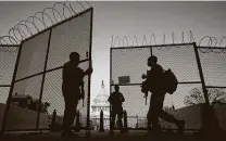  ?? Carolyn Kaster / Associated Press ?? National Guardsmen open a gate in the perimeter fence around the Capitol to allow a member in at sunrise.