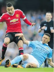  ?? JON SUPER/THE ASSOCIATED PRESS ?? United’s Jesse Lingard, left, and Manchester City’s Martin Demichelis challenge for the ball during their English Premier League match on Sunday at the Etihad stadium in Manchester.