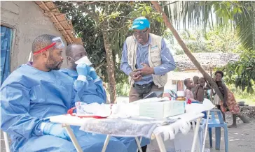  ?? AP ?? Unicef staffer Jean Claude Nzengu, centre, talks with members of an Ebola vaccinatio­n team.