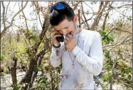  ?? AP/WILFREDO LEE ?? Florida Keys resident John Hartman uses a satellite phone Wednesday on Summerland Key to call a friend and ask for help after Hurricane Irma.