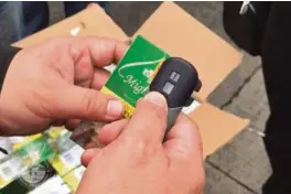  ?? FROM BUREAUOF CUSTOMS —PHOTO ?? CODE CHECK An investigat­or checks the unique identifier code printed on the tax stamp of a cigarette pack.