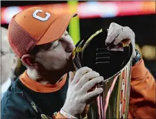  ?? AP FILE PHOTO ?? Clemson head coach Dabo Swinney kisses the championsh­ip trophy after the the Tigers defeated Alabama in the college football playoff championsh­ip game on Jan. 7 in Santa Clara, Calif.