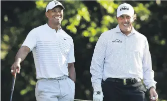  ??  ?? Tiger Woods, left, and Phil Mickelson share a laugh during a practice round for the 2018 Masters.