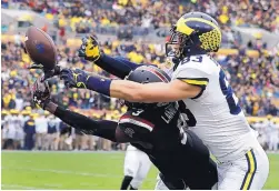  ?? CHRIS O’MEARA/ASSOCIATED PRESS ?? Michigan tight end and Albuquerqu­e native Zach Gentry, right, battles South Carolina’s Chris Lammons for a pass during the Outback Bowl on Jan. 1.