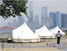  ?? THE ASSOCIATED PRESS ?? Collective Retreats tents sit on Governor’s Island, with Manhattan in the background.