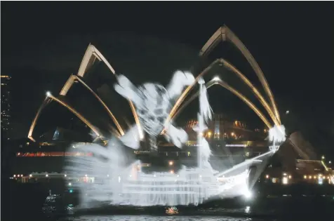  ?? — Reuters ?? A ‘ghost ship’ of light projected onto a spray of water provided by a fire tender floats past the Sydney Opera House in Sydney, Australia, on Sunday before the May 26 release of ‘Dead Men Tell No Tales’, the fifth instalment of the Pirates of the...