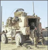  ?? KHALID MOHAMMED / AP ?? U.S. soldiers stand outside their armored vehicle south of Mosul, Iraq, in February. As Iraqi forces push into western Mosul, coalition troops are closer to frontline fighting than ever before.