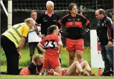  ??  ?? Michelle McMahon of Louth, right, being attended to for an injury near the end of the game.