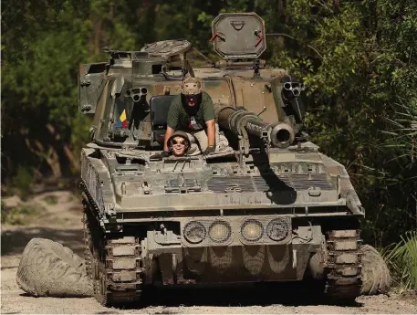  ?? TNS PHOTOS ?? BIG KIDS TOYS: Reporter Patrick Connolly takes a British FV433 Abbot model tank for a spin on an obstacle course at Tank America.