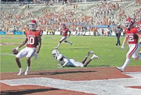  ??  ?? Oklahoma's Theo Wease (10) catches a pass for a 2-point conversion in front of Texas' Jalen Green (3) during the fourth overtime period Saturday in the Sooners' 53-45 win in front of 24,000 people at Cotton Bowl Stadium in Dallas. [BRYAN TERRY/ THE OKLAHOMAN]