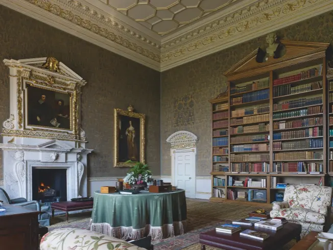  ??  ?? Fig 6: The library, with one of its gargantuan Palladian bookcases. The fine fireplace, with its copy of Van Dyke’s portrait of the Earl of Strafford and his secretary, is probably recycled from another 1740s building