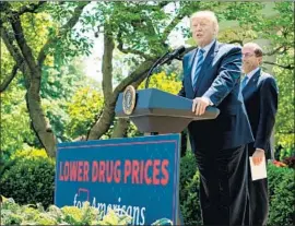  ?? Nicholas Kamm AFP/Getty Images ?? PRESIDENT Trump, with HHS Secretary Alex Azar, speaks May 11 on drug prices. Merck’s announced price cuts aren’t “much benefit at all,” an expert says.