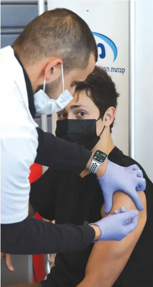  ?? (Ronen Zvulun/Reuters) ?? A TEENAGER receives a vaccinatio­n against COVID-19 in Tel Aviv, earlier this year.