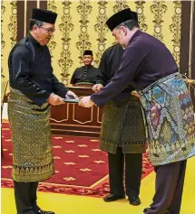  ??  ?? The King handing over the letter of appointmen­t to Md Raus at Istana Negara. — Bernama