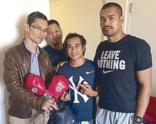  ??  ?? The late sportscast­er Hermie Rivera’s son Noel presents former champ Luisito Espinosa’s gloves and shoes as mementos for Ancajas to fighter Mark Anthony Barriga and trainers Bobby Jalnaiz and Delfin Boholst.