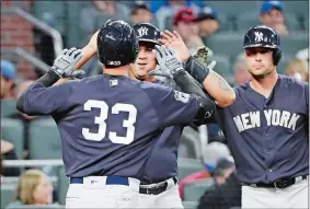  ?? DAVID GOLDMAN/AP PHOTO ?? Greg Bird of the Yankees (33) is high-fived by Gary Sanchez after they scored on Bird’s two-run homer in a spring training game against the Braves on Friday night at Atlanta. Matt Holliday, right, looks on.