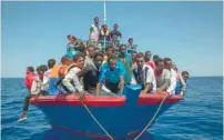  ?? — AFP ?? Migrants wait to be rescued by the Aquarius rescue ship run by NGO ‘SOS Mediterran­ee’ and ‘Medecins Sans Frontieres in the Mediterran­ean Sea, 30 nautic miles from the Libyan coast, last Thursday.