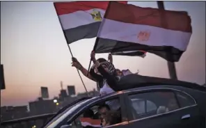  ??  ?? LEADERSHIP TALKS: Supporters of the Tamarrod or Rebel movement wave Egyptian flags Sunday in Cairo, Egypt. Egypt’s new leadership wrangled over the naming of a prime minister, as both the Muslim Brotherhoo­d and their opponents called for new mass...