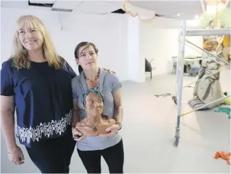  ?? ADRIAN LAM, TIMES COLONIST ?? Marion Selfridge, left, and Naomi Kennedy, curator and artist, at the heArt space venue on Fort Street. Kennedy is holding a clay figure of a friend.