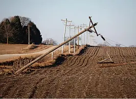  ?? Bryon Houlgrave/The Des Moines Register via AP ?? ■ Utility poles lay in a field Thursday near Jefferson, Iowa, after a band of severe weather produced strong wind gusts and reports of tornadoes across much of the state Wednesday night. The storm caused property damage and downed power lines, leaving many Iowans without electricit­y.