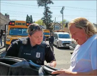  ?? PHOTO PROVIDED ?? Troy Police Officer Karrie Hoover shows Amy Fayoumi, a driver and instructor for Star and Strand Transporta­tion, how to properly install a child safety seat.