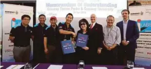  ??  ?? Calvin Ho (fourth from left) and Dr Elizabeth Lee exchanging documents after signing a memorandum of understand­ing between Sunway Theme Parks and Sunway University.
