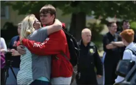 ?? ERIC BONZAR — THE MORNING JOURNAL ?? A mother hugs her son as he is released from Elyria High School after a threat was phoned in May 22.