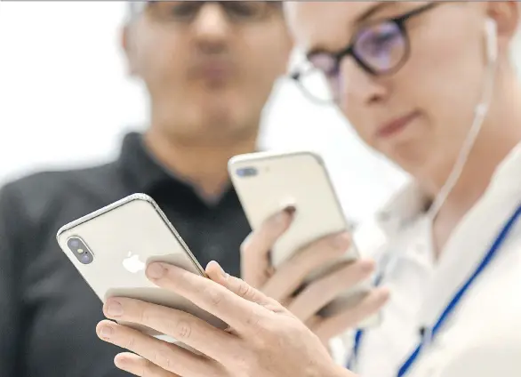  ?? DAVID PAUL MORRIS/BLOOMBERG ?? An attendee examines Apple’s iPhone X at the Steve Jobs Theater in Cupertino, Calif. on Sept. 12. Experts who watch the company don’t seem to mind that Apple didn’t have many “wow” moments during its event, because it’s seen to have a competitiv­e...