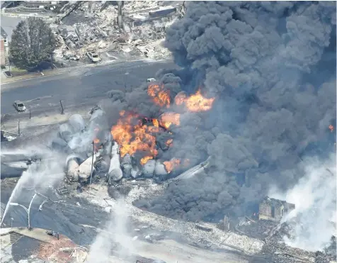  ?? THE CANADIAN PRESS FILES ?? Smoke rises from railway cars that were carrying crude oil after derailing in downtown Lac- Megantic, Que., on July 6, 2013, killing 47 people.