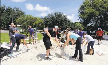 ?? ALAN DIAZ — THE ASSOCIATED PRESS ?? Above, volunteers in Miami help residents fill free sandbags Thursday in preparatio­n for Hurricane Irma. A hurricane watch is now in effect for the Florida Keys and parts of South Florida.