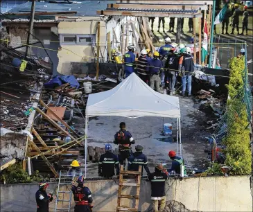  ?? JOSE MENDEZ / EFE / ZUMA PRESS / TNS ?? Rescuers and volunteers search for victims under the debris of a school that collapsed in Mexico City. The country was transfixed by reports of a 12-year-old girl signaling to rescuers from under the rubble, but Thursday afternoon, the Mexican navy...